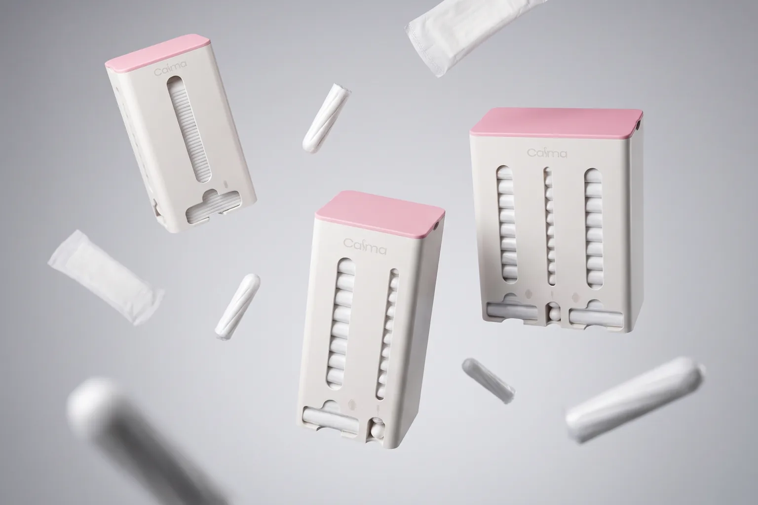 De drie CALMA dispensers Mini, Essentials en Max zwevend, met losse tampons en inlegkruisjes
